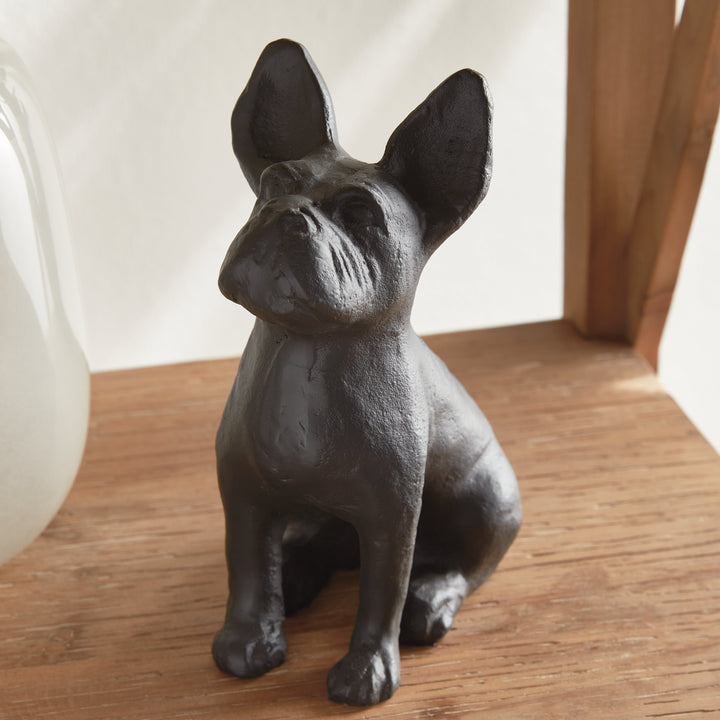 Hand-cast black aluminum dog sculpture sitting upright on tabletop with forward gaze, compact 8.5 inch size for shelf styling.