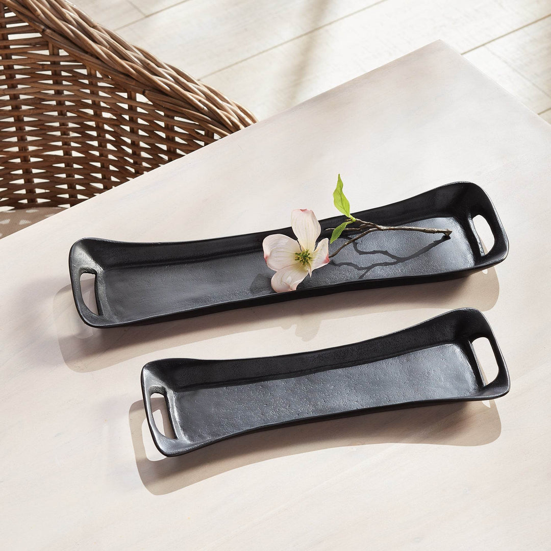 Black metal trays styled with a single flower on a pale surface – Urban Contemporary.

