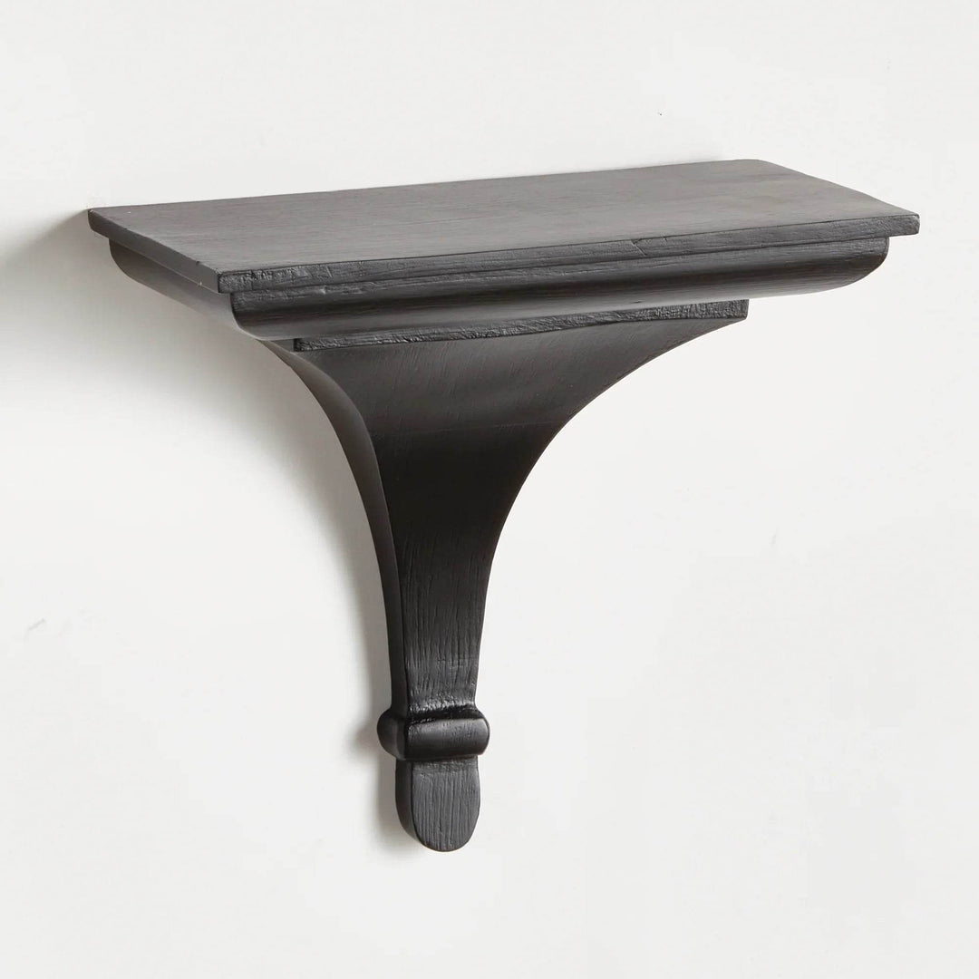 Black wood decorative wall bracket shelf with curved corbel design, mounted on wall and shown from the front in sharp detail.