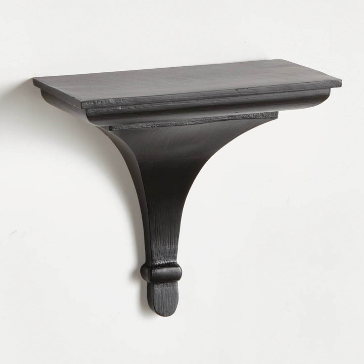 Black wood decorative wall bracket shelf with curved corbel design, mounted on wall and shown from the front in sharp detail.