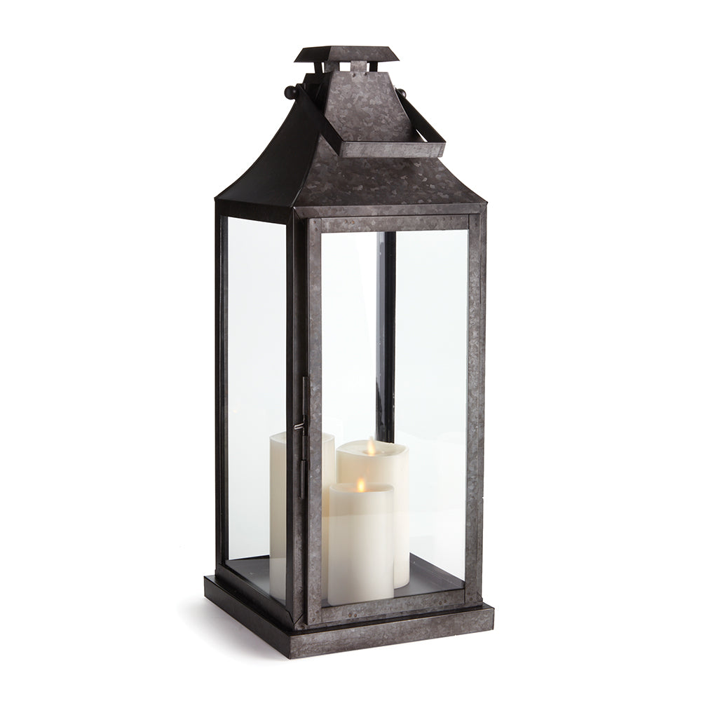 Black galvanized metal outdoor lantern with glass panels and candle interior for transitional patio decor style