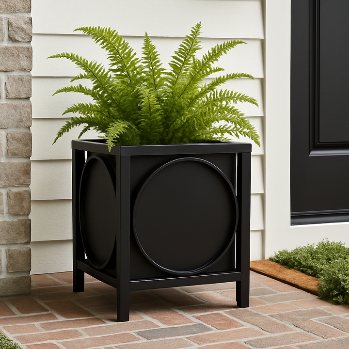 Black iron planter with bold circle detail styled on a brick porch with gray siding, ideal for urban entryways and modern outdoor curb appeal.