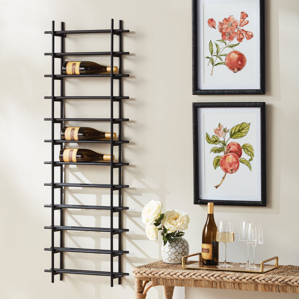 Vertical black iron wall wine rack for 12 bottles, styled in dining room beside framed fruit prints, console, and wine glasses.