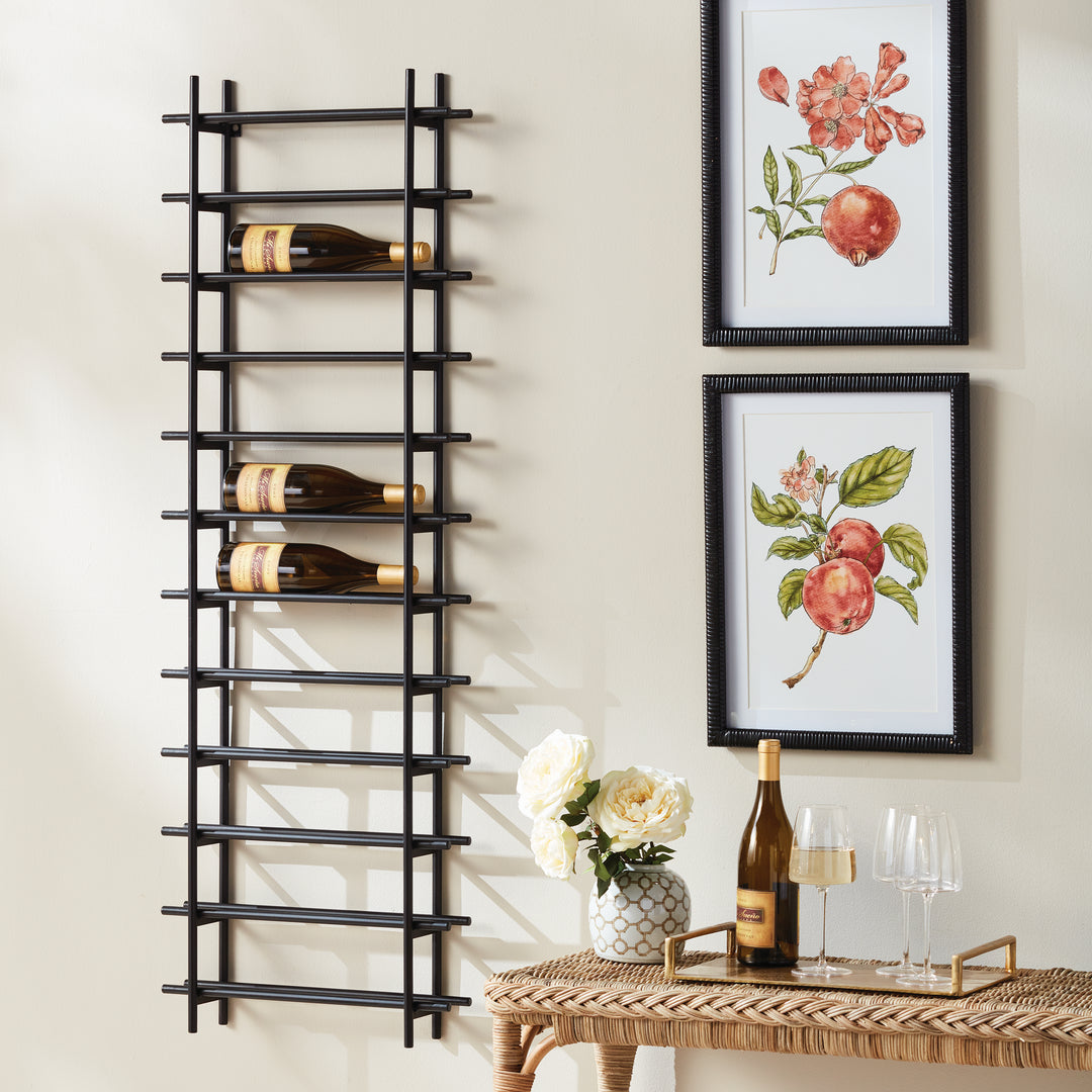 Vertical black iron wall wine rack for 12 bottles, styled in dining room beside framed fruit prints, console, and wine glasses.
