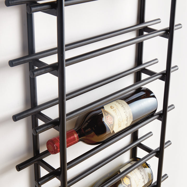 Detailed side view of black iron vertical wall wine rack showing wine bottles resting in sturdy round metal stock construction.
