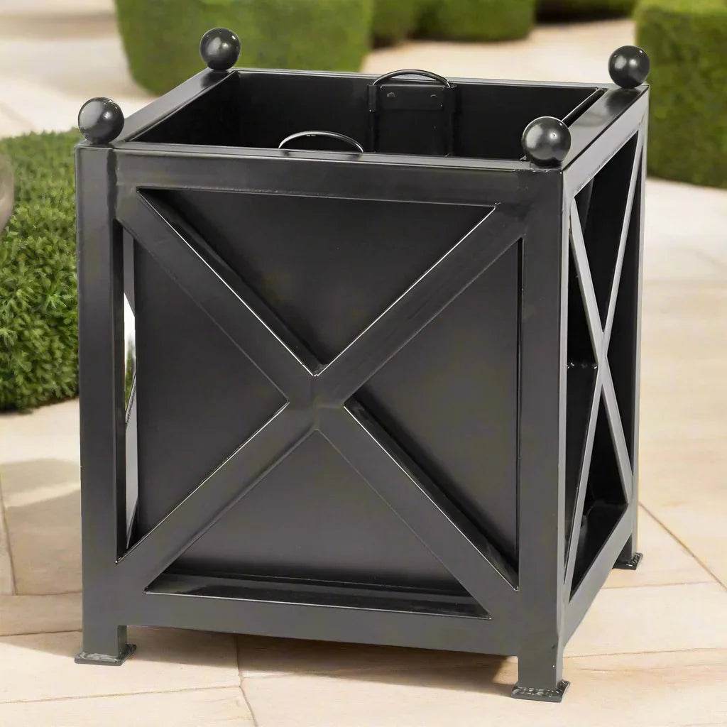 Modern black iron planter with X-frame detailing placed on patio stone surface