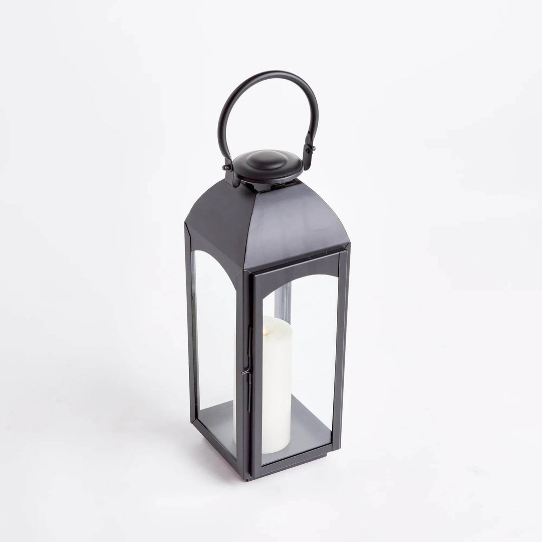 Large black outdoor lantern in powder-coated iron with glass panels, 3/4 view on white, ring handle visible – Transitional Decor