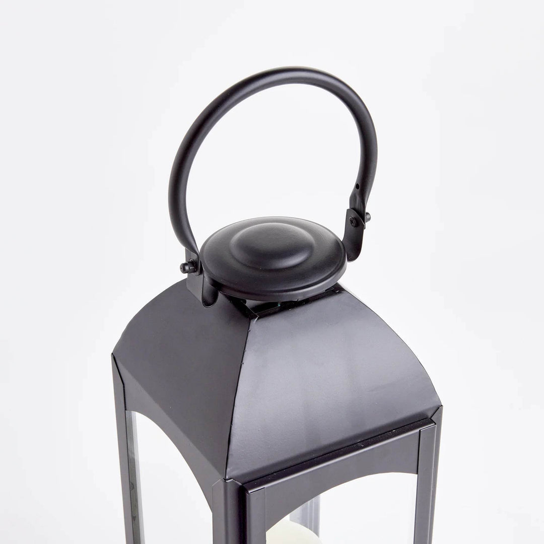 Close-up of domed top and handle on black outdoor lantern; powder-coated finish, vented cap hardware detail – Transitional Decor