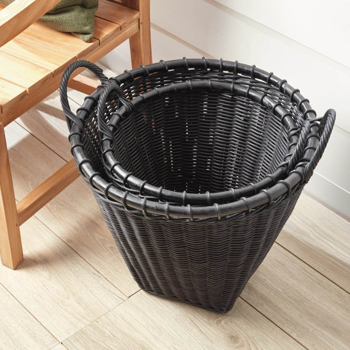Black rattan basket under a bench; tapered shape and side handles make a neat catch-all for blankets or toys – Modern Boho.