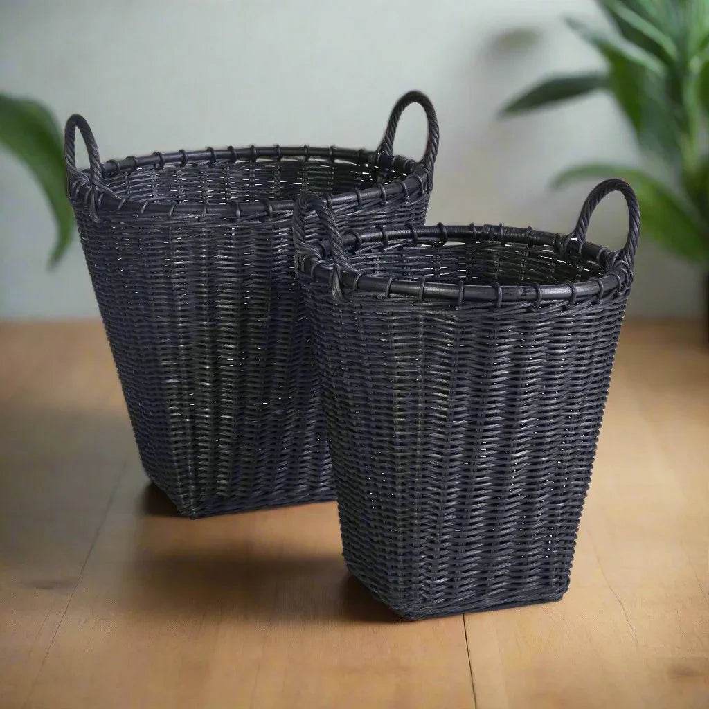 Set of two black rattan baskets with tapered sides and wrapped handles, styled on wood floor for storage needs – Modern Boho.