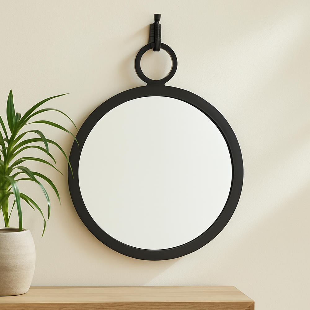 Minimalist bedroom with black round wall mirror and coastal-inspired neutral decor on soft white wall