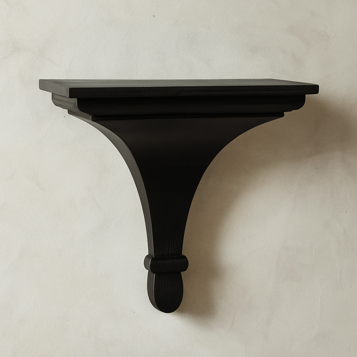 Close-up of black bracket shelf in entryway vignette with neutral backdrop, styled with vintage books and sculptural object.
