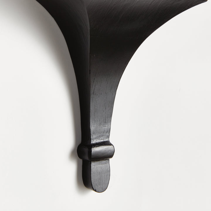 Wall-mounted black corbel bracket holding a trailing green plant, styled for modern gallery wall or minimalist decor.