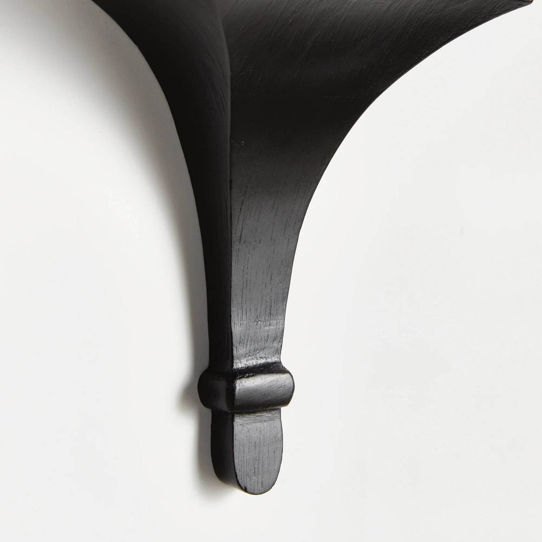 Wall-mounted black corbel bracket holding a trailing green plant, styled for modern gallery wall or minimalist decor.