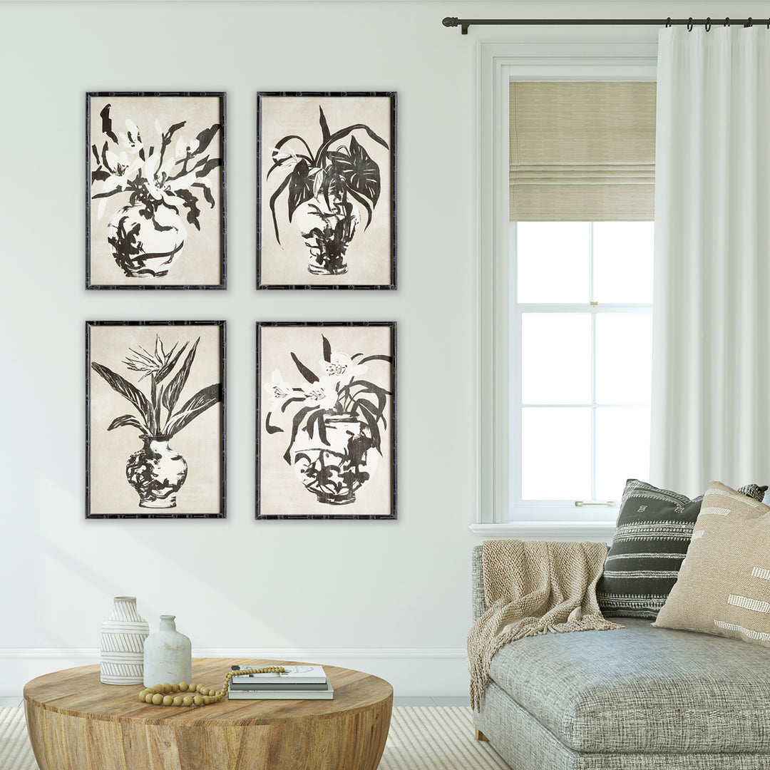 Four black and white botanical prints in black bamboo-style frames, arranged in a grid above a pale round table, Traditional