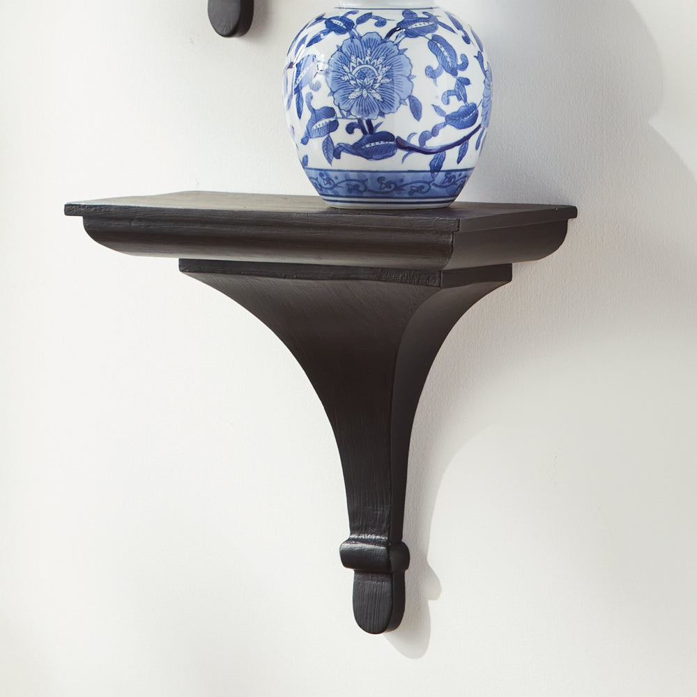 Side angle of black wood wall corbel bracket with sculpted base, ideal for small plants or decorative home accessories.