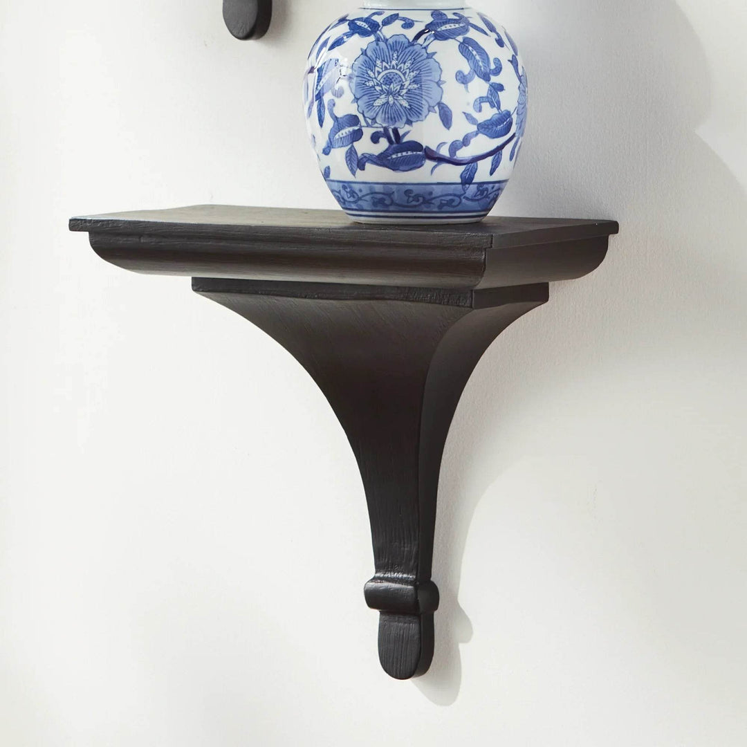 Side angle of black wood wall corbel bracket with sculpted base, ideal for small plants or decorative home accessories.