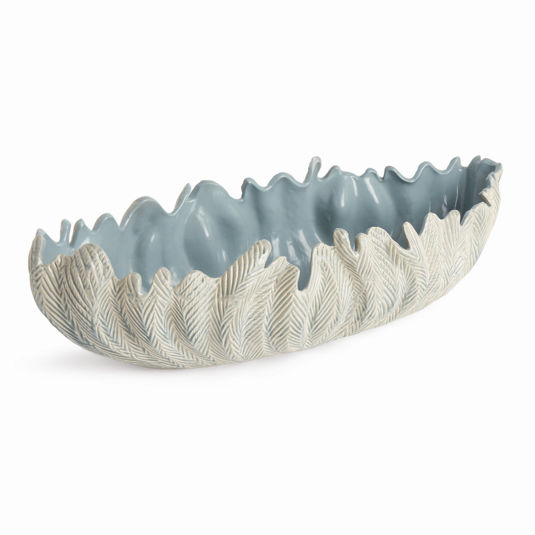 Handcrafted blue ceramic decorative oval bowl with carved leaf exterior and wavy rim, shown at full angle on white background – Modern Organic.