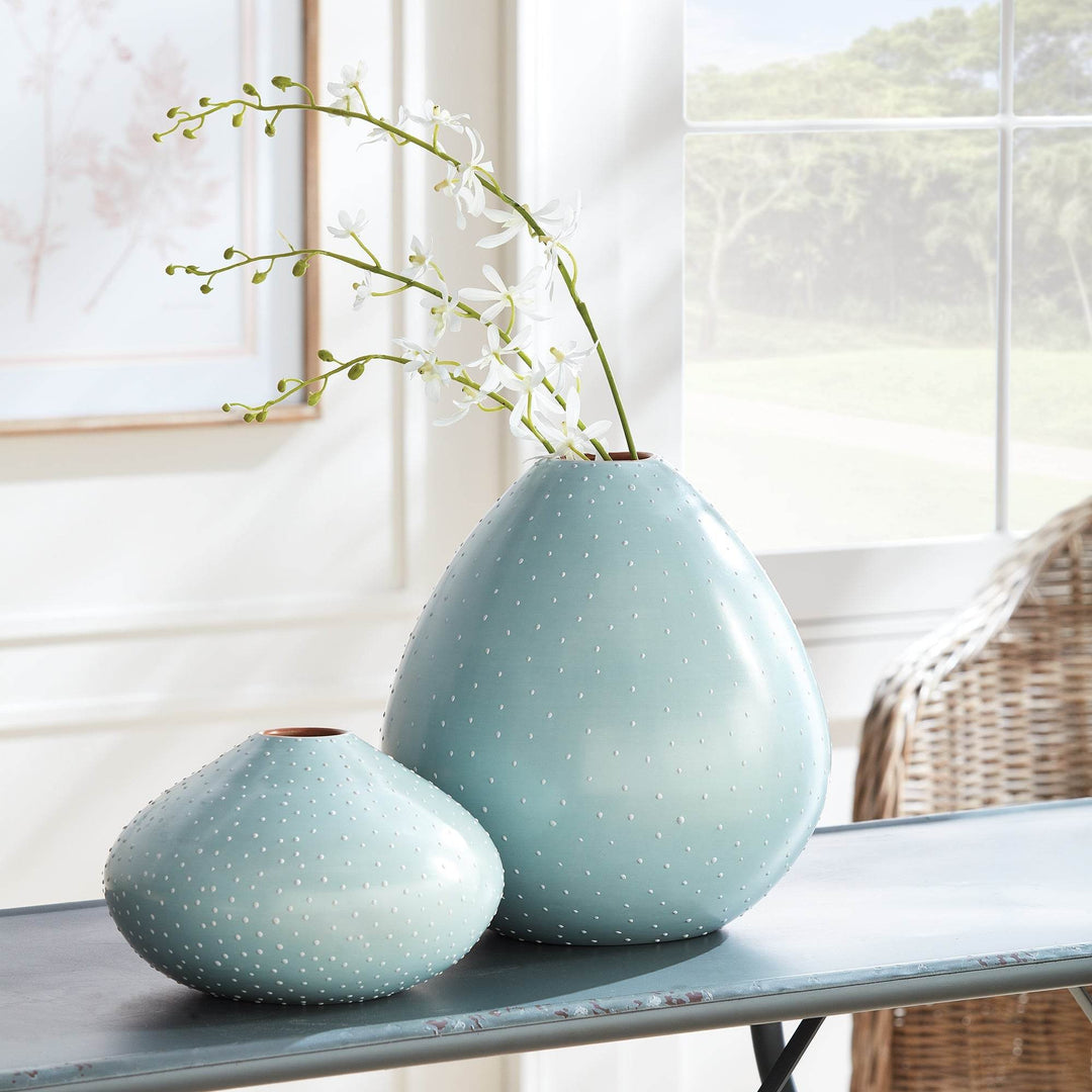 Styled ceramic vase pair showing medium and large blue vases with white stipples and orchid stem on table – Modern Organic.

