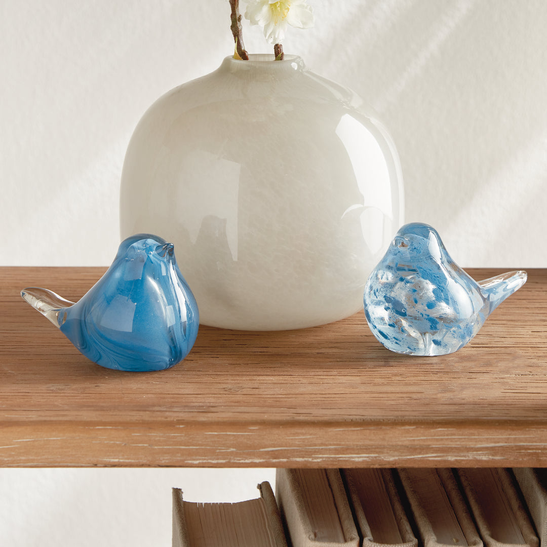 Hand blown blue glass finch sculptures styled on console table, sculptural bird accents adding color to interior décor.
