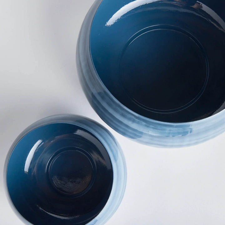 Overhead view of two enameled iron bowls, showing glossy dark interiors and coastal blue gray hand-painted design – Coastal