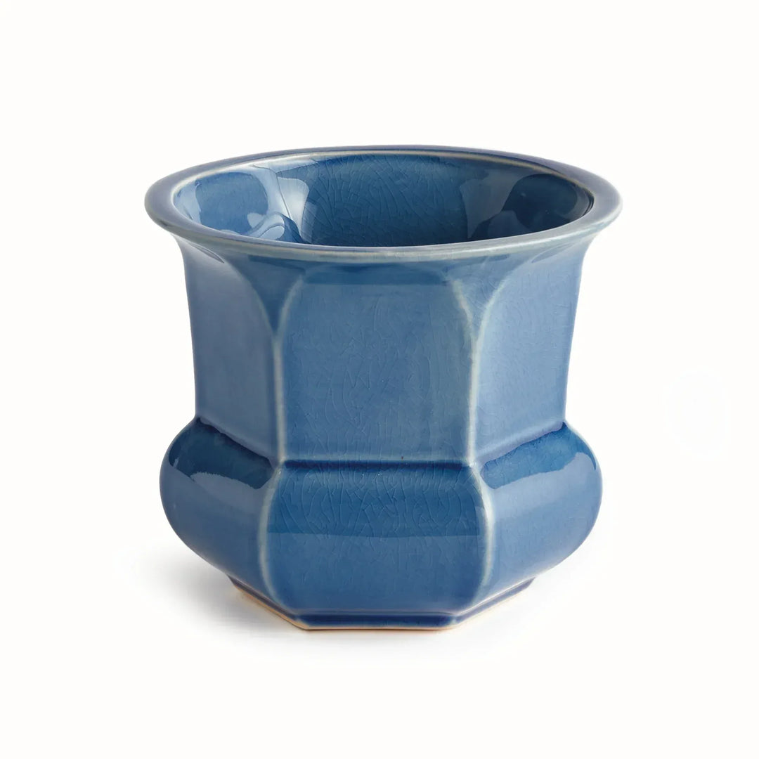 Blue reactive glaze ceramic planter with a flared rim, faceted sides and a rounded base, shown on plain white, Traditional