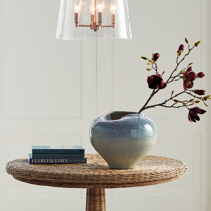 Blue reactive glaze stoneware vase displayed on a round wood table with decorative branches – Modern Organic