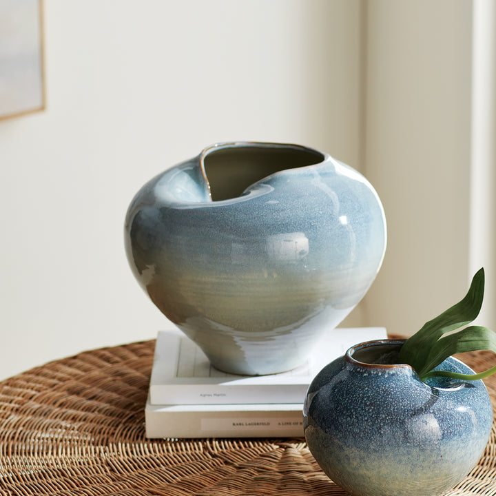 Blue reactive glaze stoneware vases styled on a woven console surface with layered decorative accents – Modern Organic