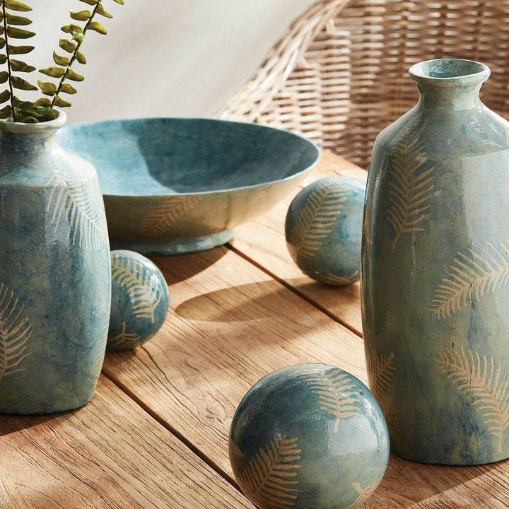 Tall decorative vase shown with matching bowl and accents in a soft neutral room