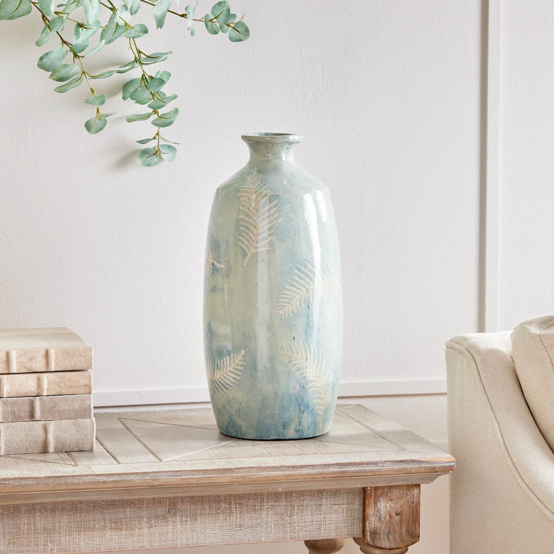 Decorative vase in dusty blue shown in styled room setting on console with books and greenery