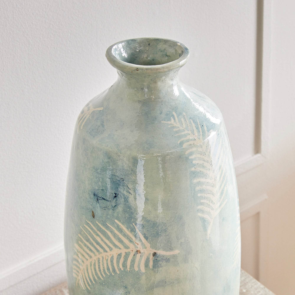Side detail of tall blue vase showing organic fern pattern and matte finish