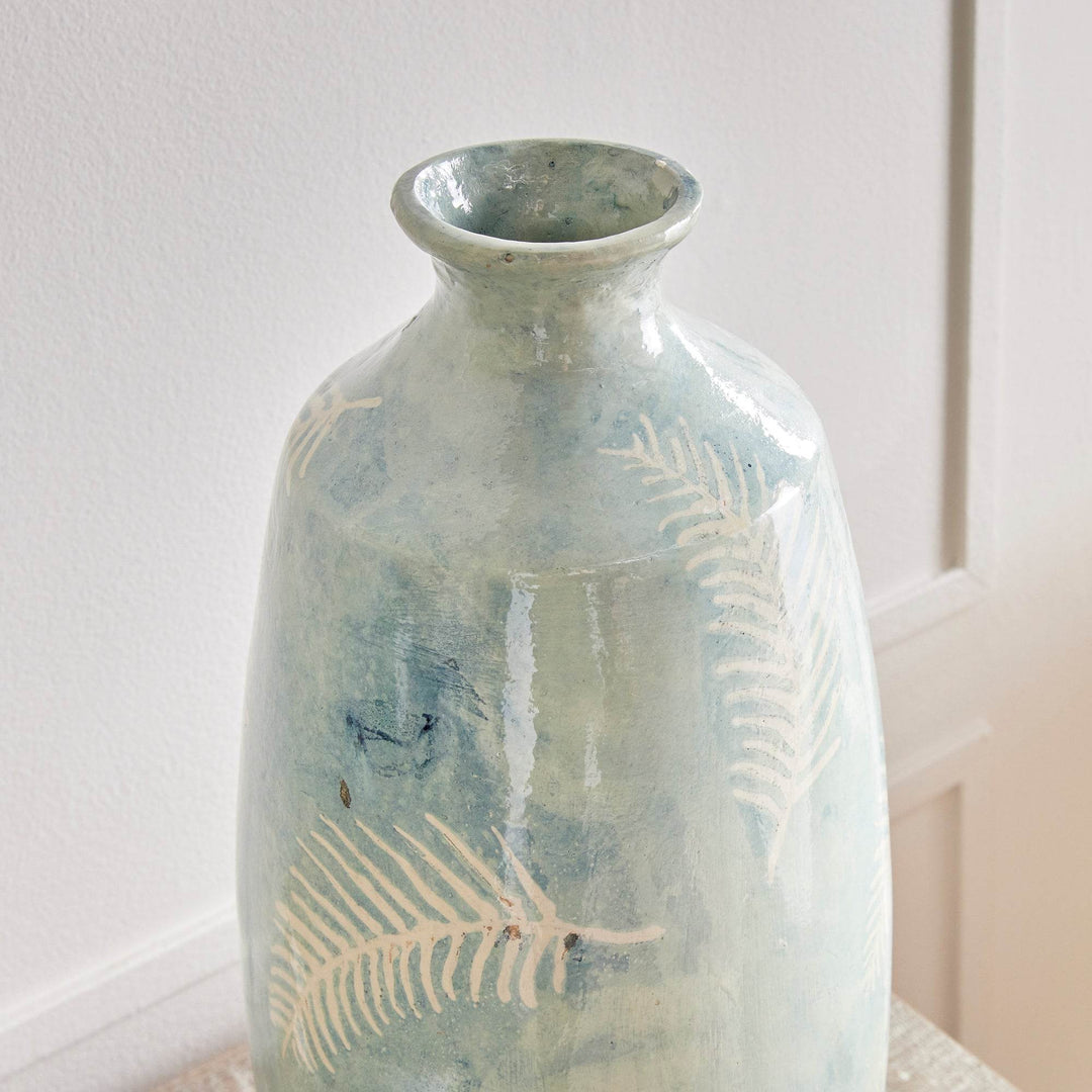 Side detail of tall blue vase showing organic fern pattern and matte finish