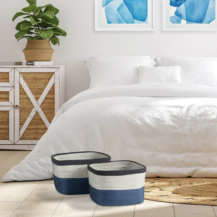 Blue and white rectangular woven storage baskets styled in bedroom near bed and cabinet for coastal home decor and organized living – Casual Coastal.

