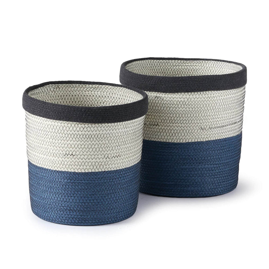 Set of two round woven storage baskets in blue and white color-blocked design, shown nested together on white background – Coastal Modern.

