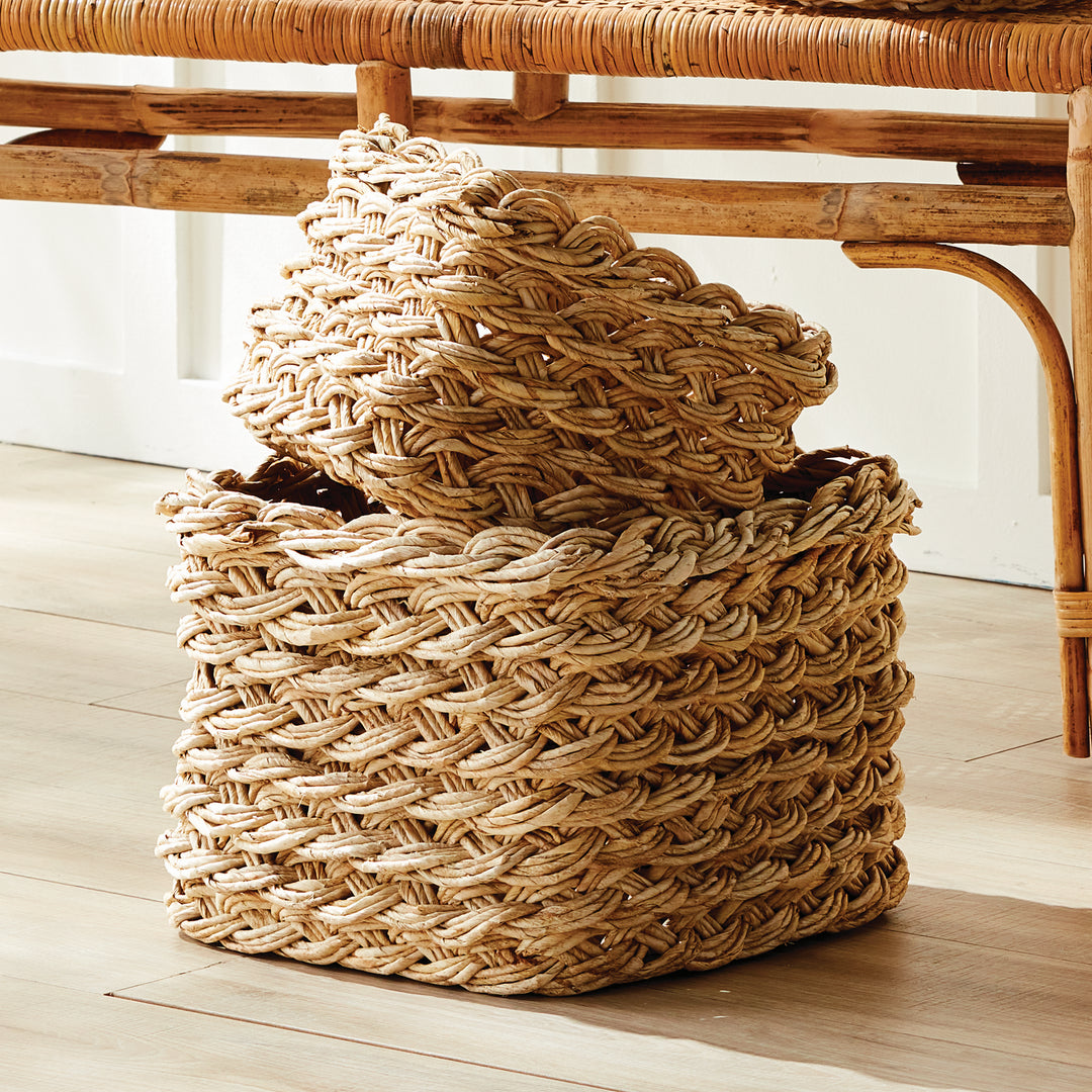 Square abaca French braid baskets styled under entryway bench, showing natural tan fiber and artisan weave – Boho Home Décor