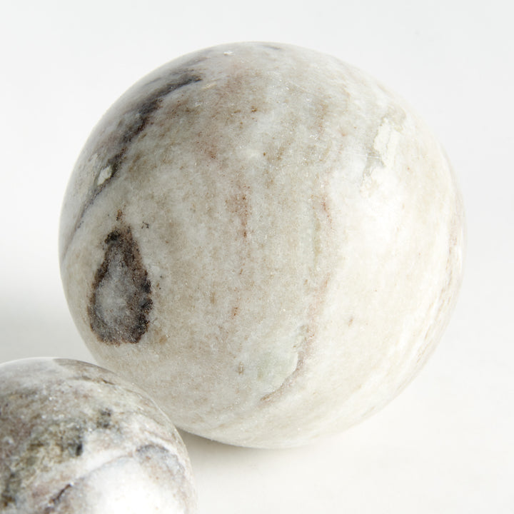Detail of a pale marble orb with brown veining and semi-matte finish, with part of a smaller sphere visible. Modern Organic