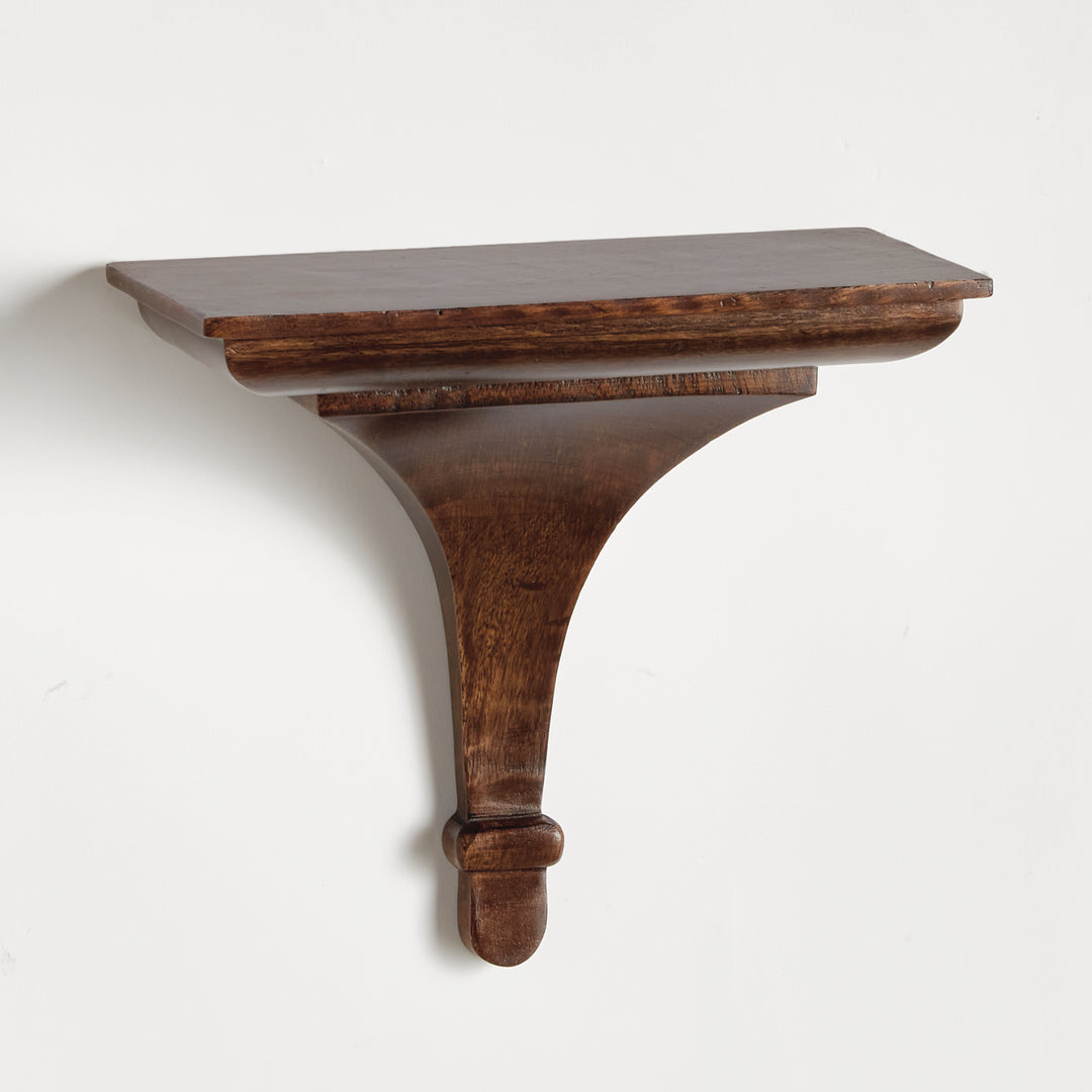 Antique brown wall-mounted display shelf with soft taper and architectural profile, shown in clean side-angle studio setting.

