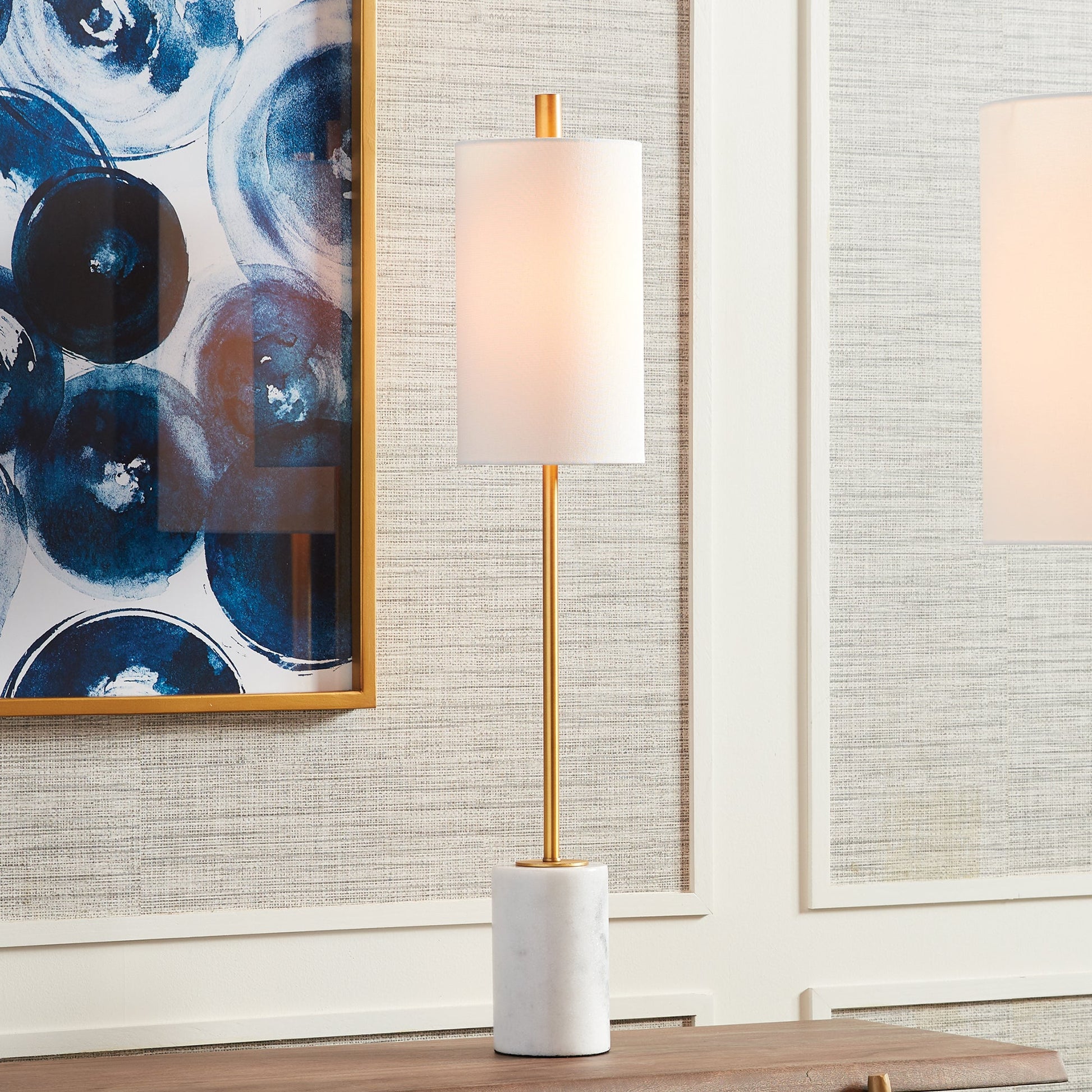 This lamp boasts an intriguing blend of marble and brass elements, creating a visually striking piece. The tall, narrow base and carefully crafted shade are impeccable touches that should not be overlooked. Its antique gold finish adds a touch of modern, contemporary flair.