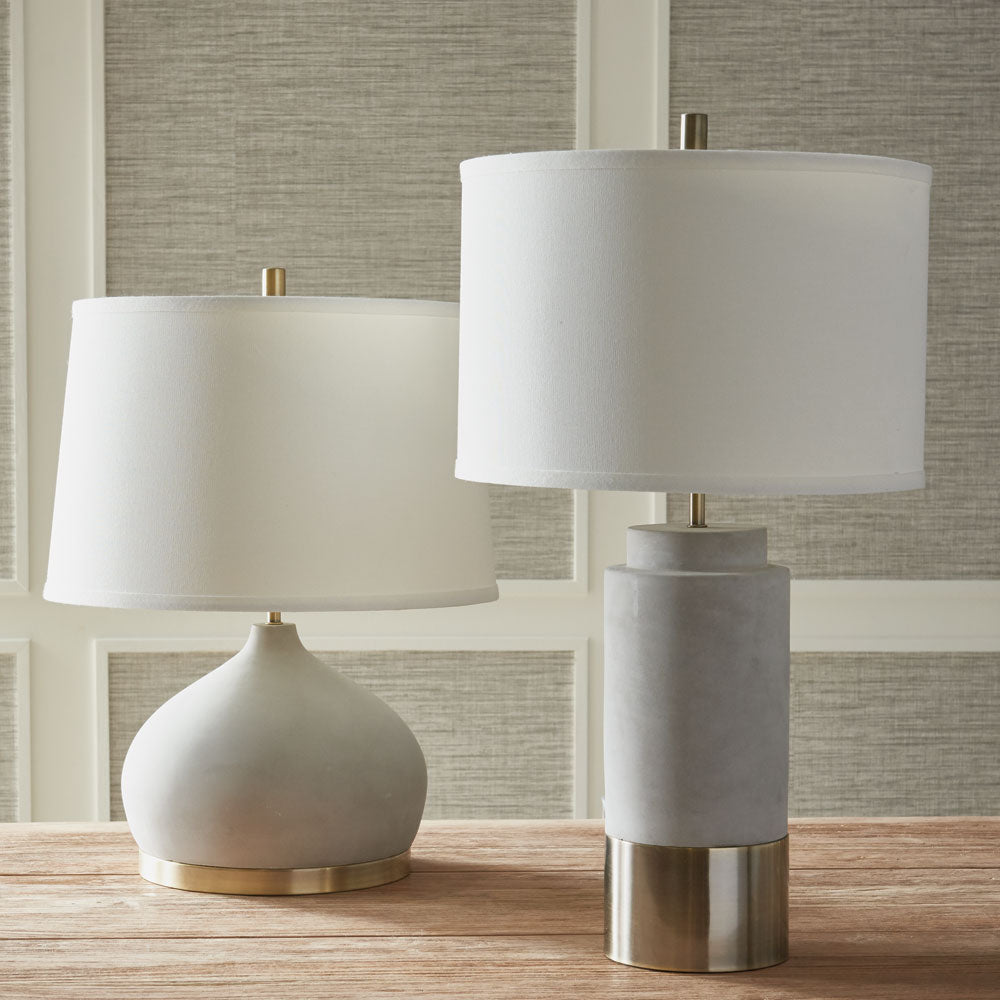 Constructed with both function and fashion in mind, the Suki lamp is a one-of-a-kind fixture that combines cement and brass accents. Its curvy base and wide shade make for distinctive details that add personality and style to any room. Crafted from premium ceramic with a concrete finish and complemented by antique brass accents, this lamp not only stands out but also ensures lasting durability for years of enjoyment.