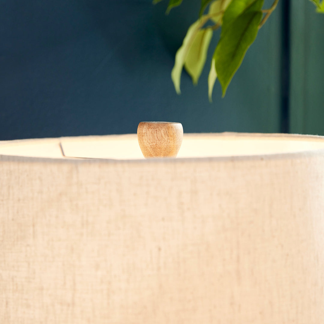 This table lamp features a composite base made of natural Eco mix, incorporating hardening agents for long-lasting durability. The warm white finish adds a subtle texture, showcasing the unique composition of the material. Topped with a linen tapered shade and banded silhouette, this petite lamp is perfect for bedside tables or desks. Designed with sustainability in mind, it utilizes an Eco mix made from natural materials, combining durability with eco-friendliness.