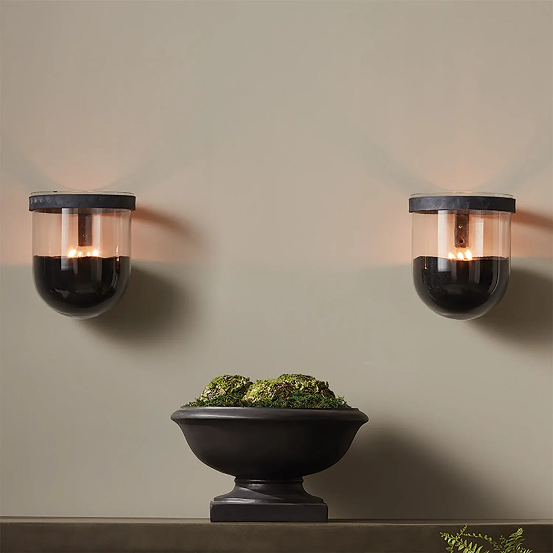 Black candle sand used in wall mounted glass holders creating modern ambient lighting with floating candle effect