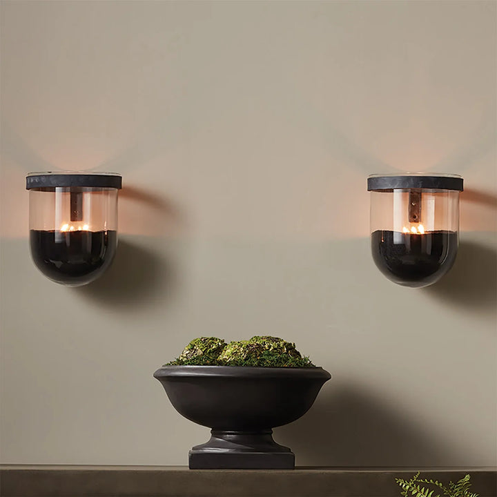 Black candle sand used in wall mounted glass holders creating modern ambient lighting with floating candle effect