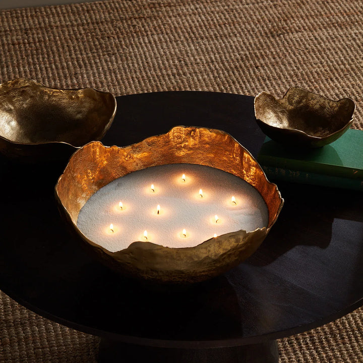 Top view of white candle sand in organic brass vessel with evenly spaced wicks creating soft ambient candlelight