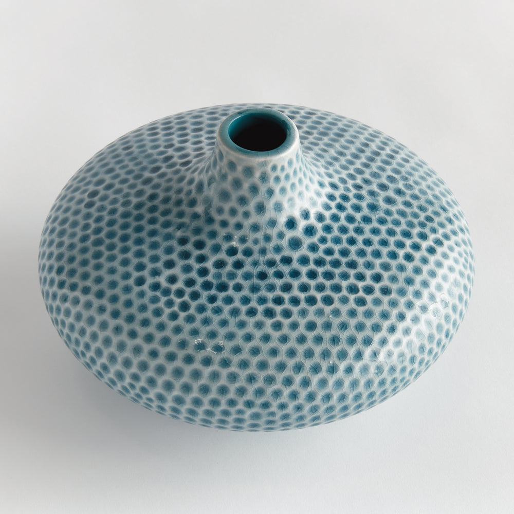 Top angle view of Carys low blue vase showing the small opening, broad circular shoulders and organic dotted texture. Coastal