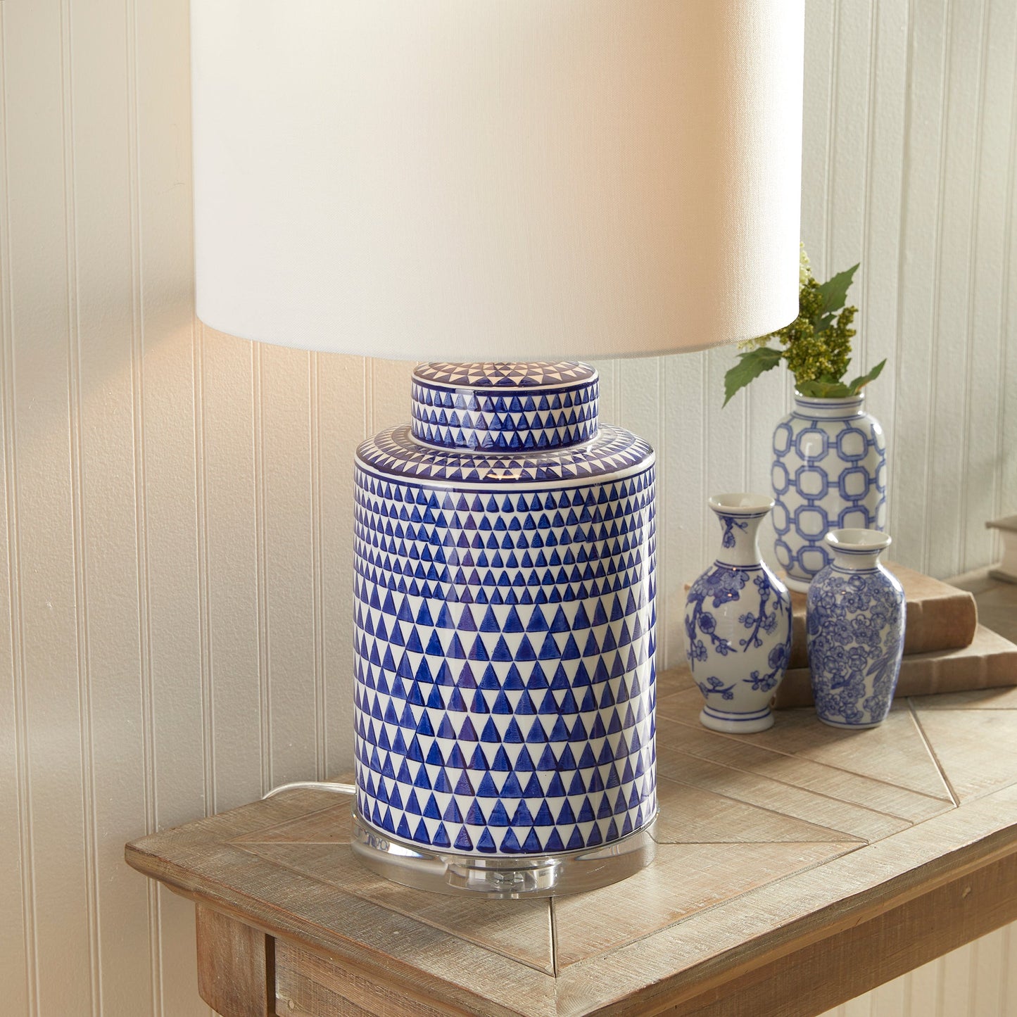 This table lamp features a traditional design in a classic blue and white ceramic ginger jar shape. Its elegant appearance adds a touch of blue to any traditional space. It also includes a crystal finial, weighs 16.5 lbs, and comes with a round shade.