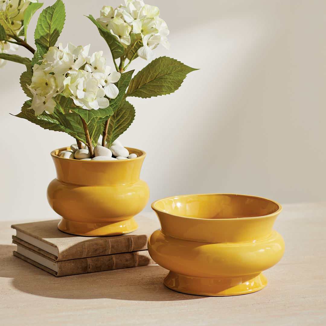 Glossy ceramic cachepot styled with fresh white flowers on stacked books, creating a classic indoor tabletop display – English Country