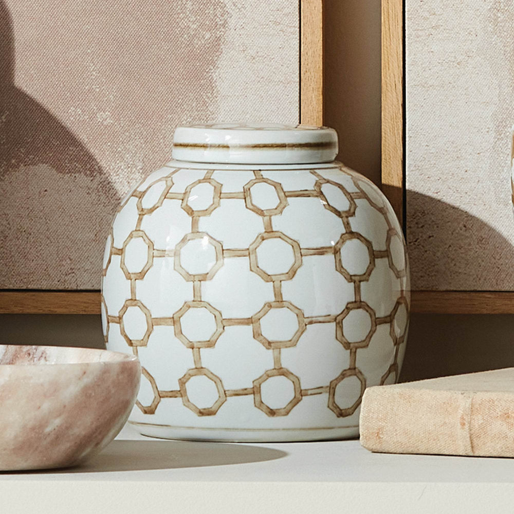 Brown and white ceramic lidded jar with geometric link pattern, styled on console with artwork and decorative accents for Transitional décor.