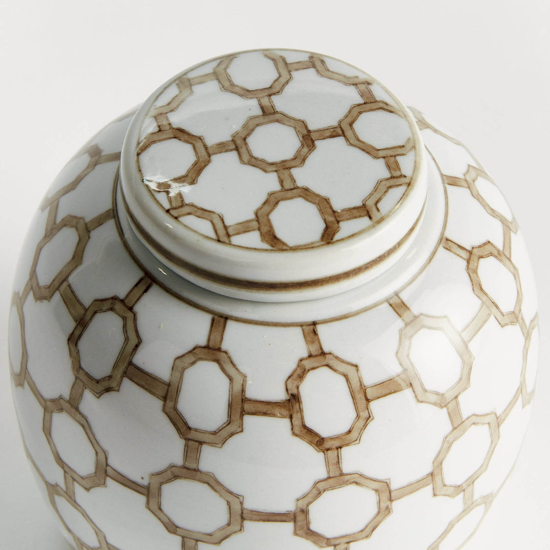 Close-up of ceramic lidded jar lid showing brown and white geometric link pattern with smooth glazed finish and artisan detail.