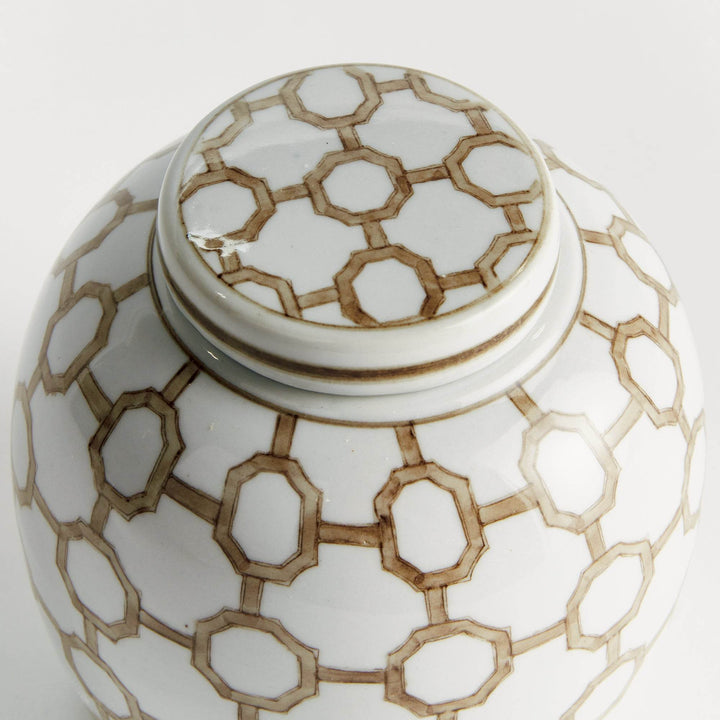 Close-up of ceramic lidded jar lid showing brown and white geometric link pattern with smooth glazed finish and artisan detail.