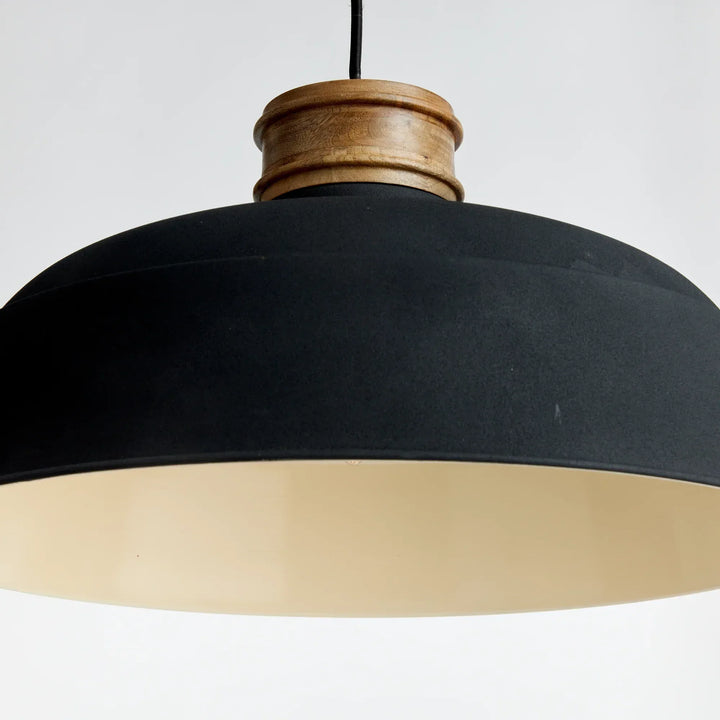 Close-up side angle of charcoal pendant lamp with wood collar and soft interior curve – modern organic style.